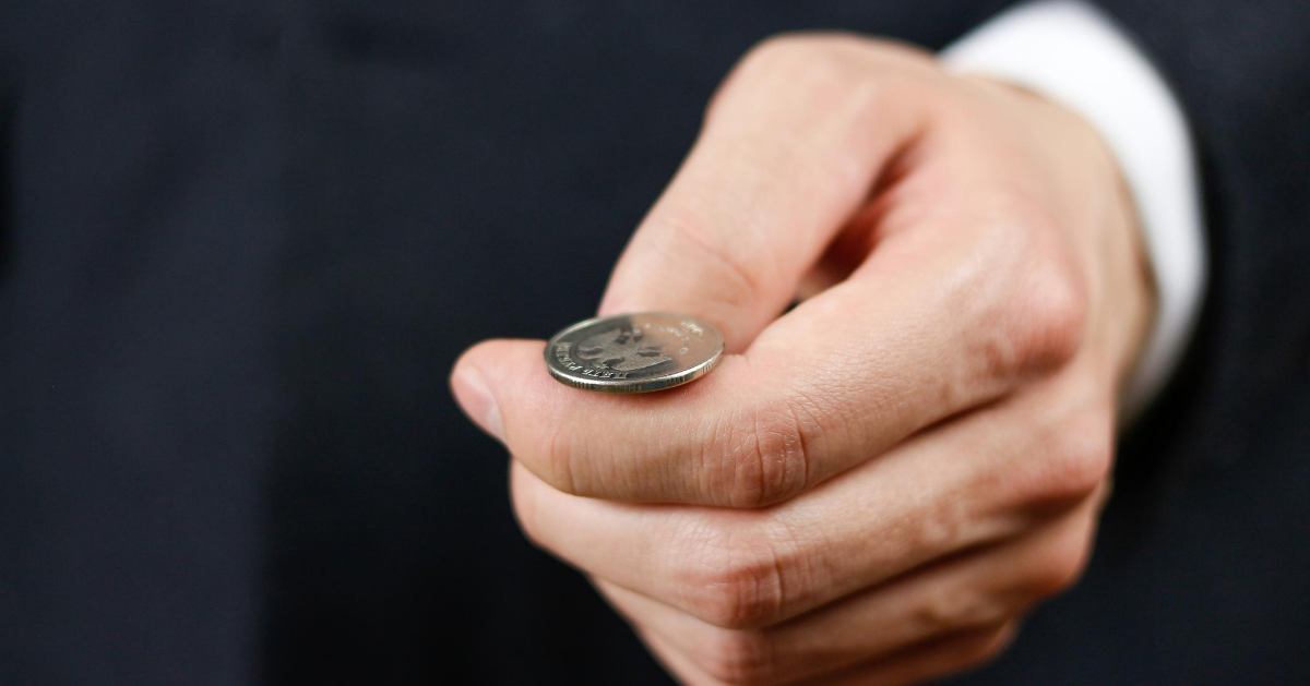 Businessman hand just about to flip a coin